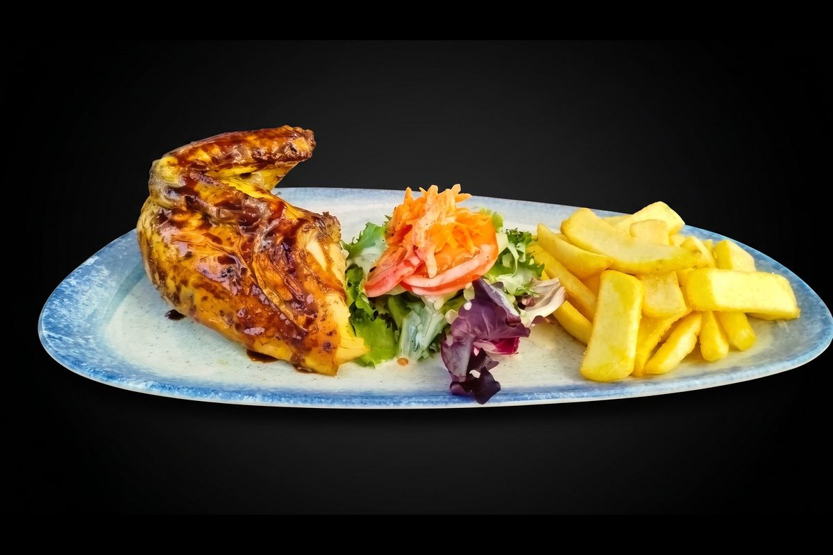 Pollo a la brasa en la mesa con sus cremas
